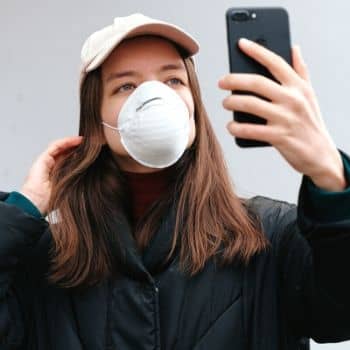 Woman wearing covid mask taking selfie